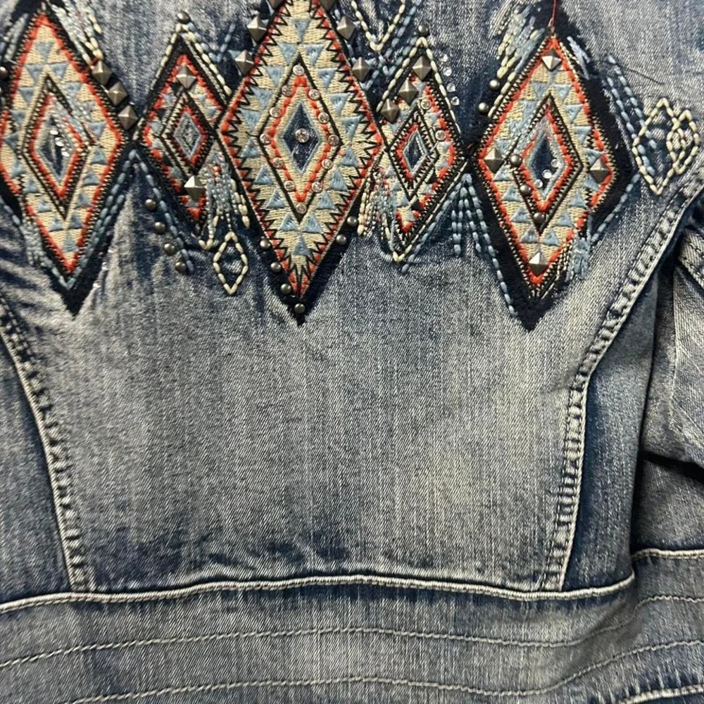 Blue denim jacket with embroidered sleeves,‎ featuring a boho western vibe